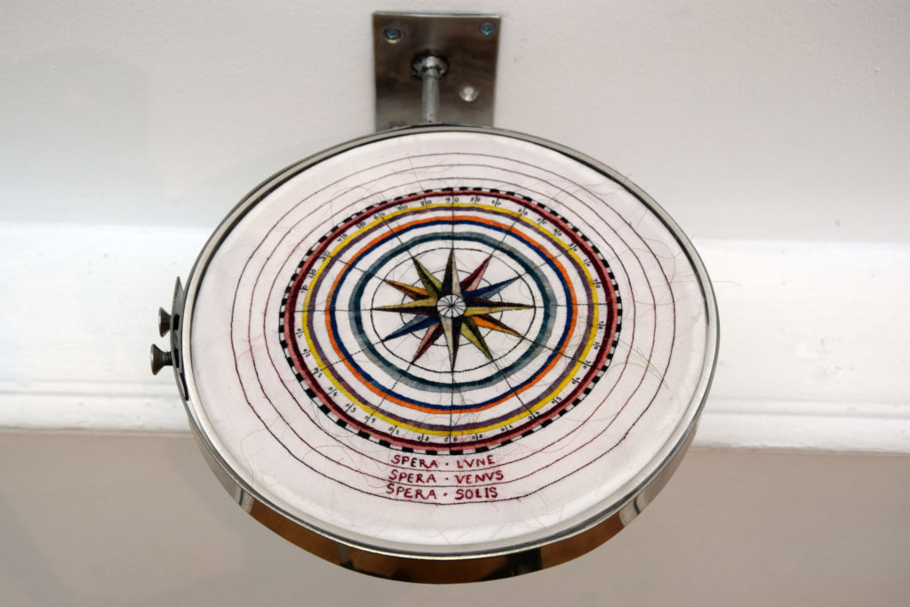 Portulans I, Rosa Nautica, 2023, broderie en cheveux naturels et colorés sur soie, support en plexiglas, inox, 10 x 20 x 20 cm. - Laura SANCHEZ FILOMENO